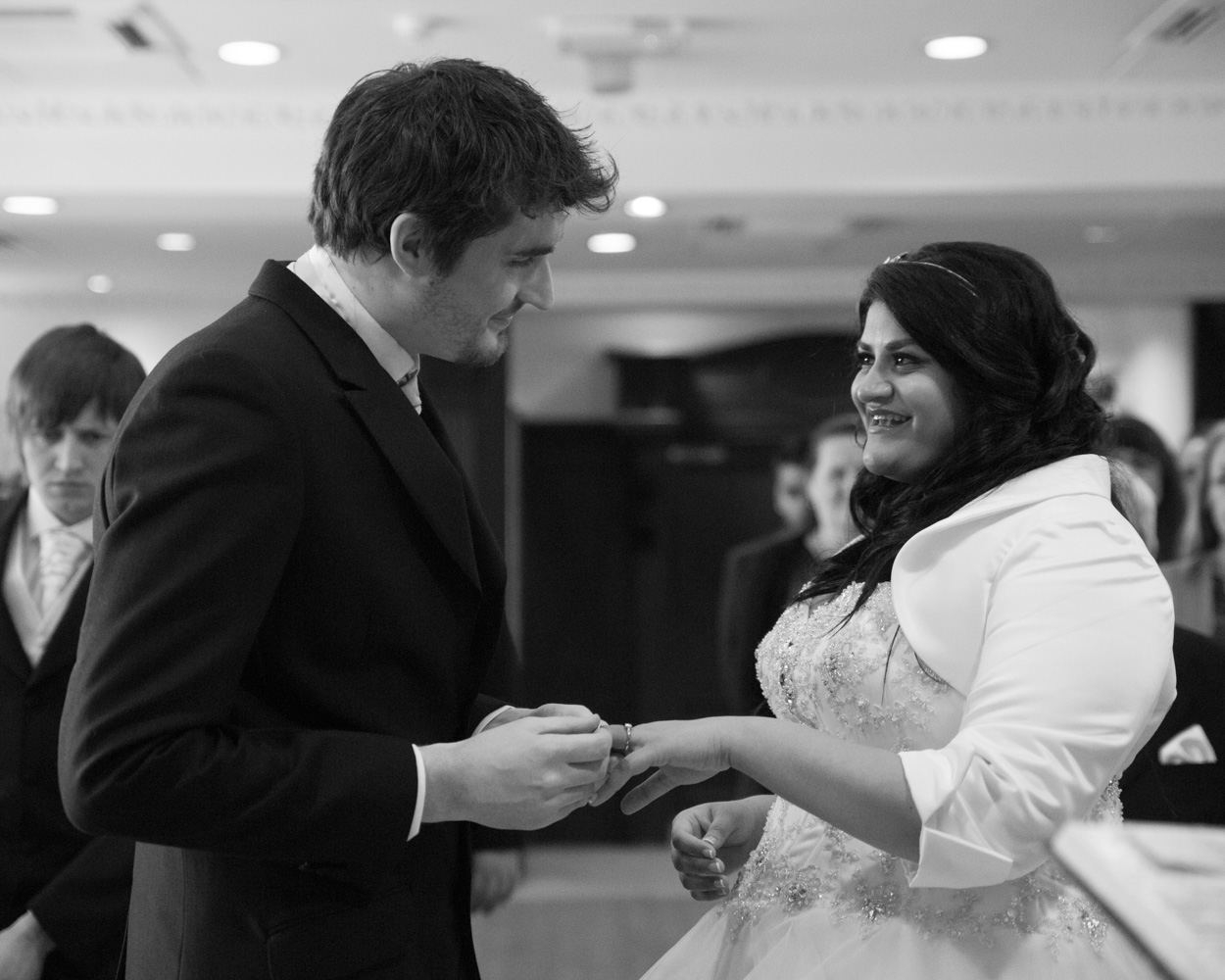 Bride and groom exit the ceremony in black and white, smiling and joyful