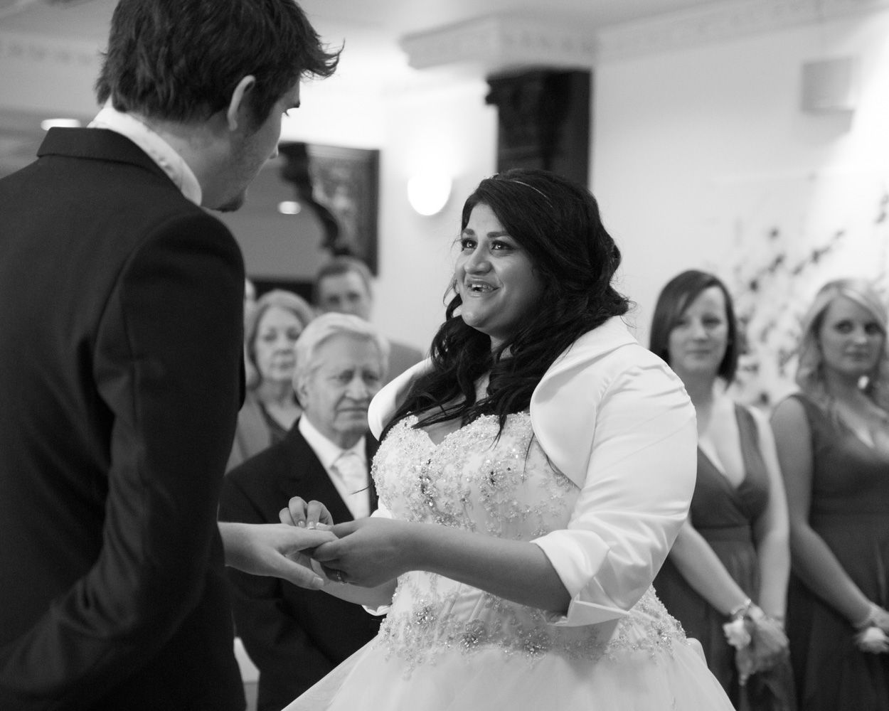 Bride and groom exit under the colourful ceiling lights at Crowne Plaza Leeds