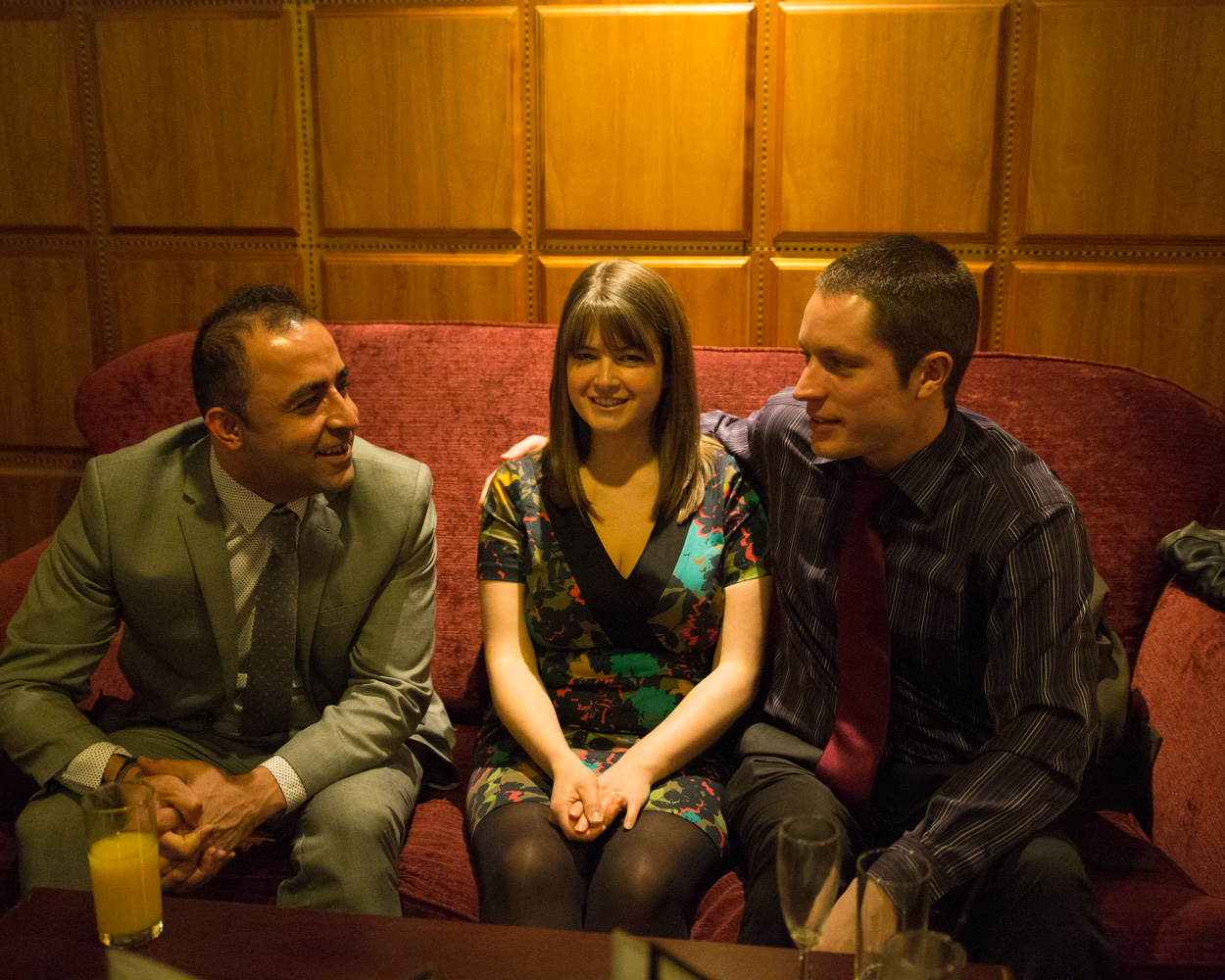 Three guests seated, one girl catching the camera with a knowing smile