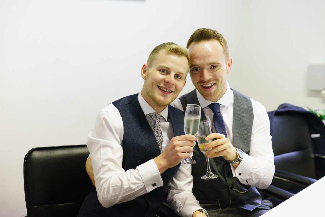 Grooms clinking glasses in Leeds