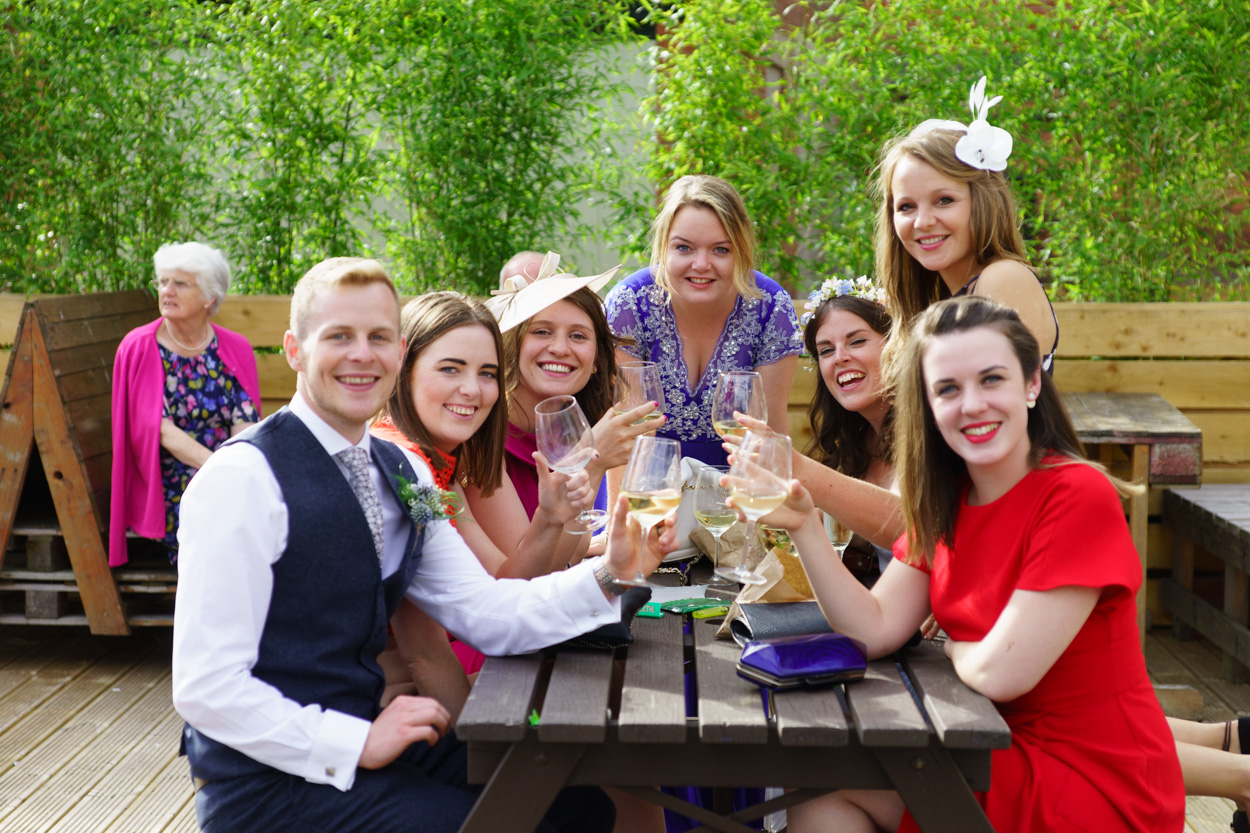 Guests and groom on the patio area pose for a photo