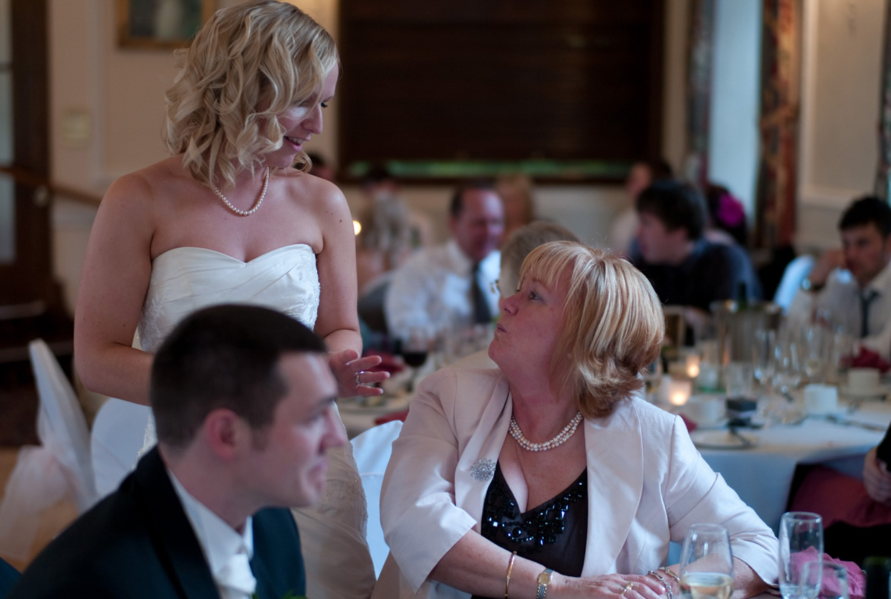 Bride visits guests at the tables in the wedding breakfast room
