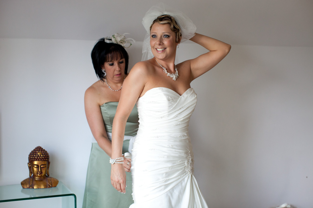 Bride lifting her veil with confidence, striking a stylish pose.