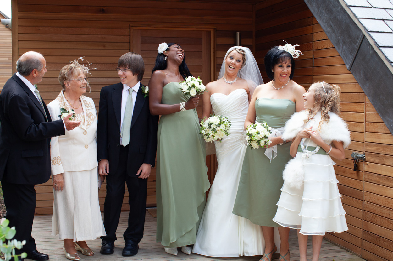 Bride and bridesmaids gathered outside the cabin, chatting and smiling.