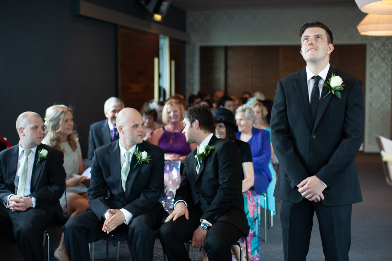 Groom standing alone, looking up thoughtfully before the ceremony.