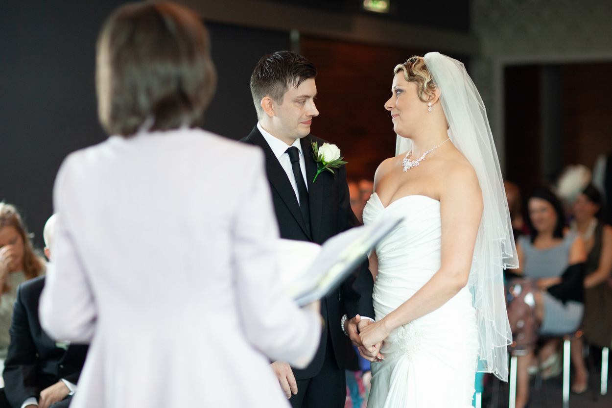 Couple standing before the registrar, facing each other during the ceremony.