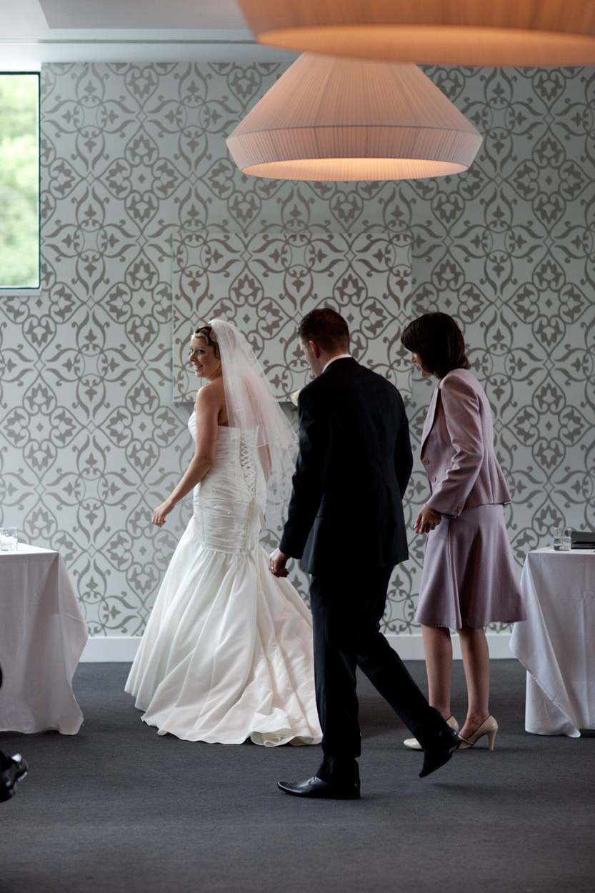 At the register table, Sam applies lip gloss as their son joins them.
