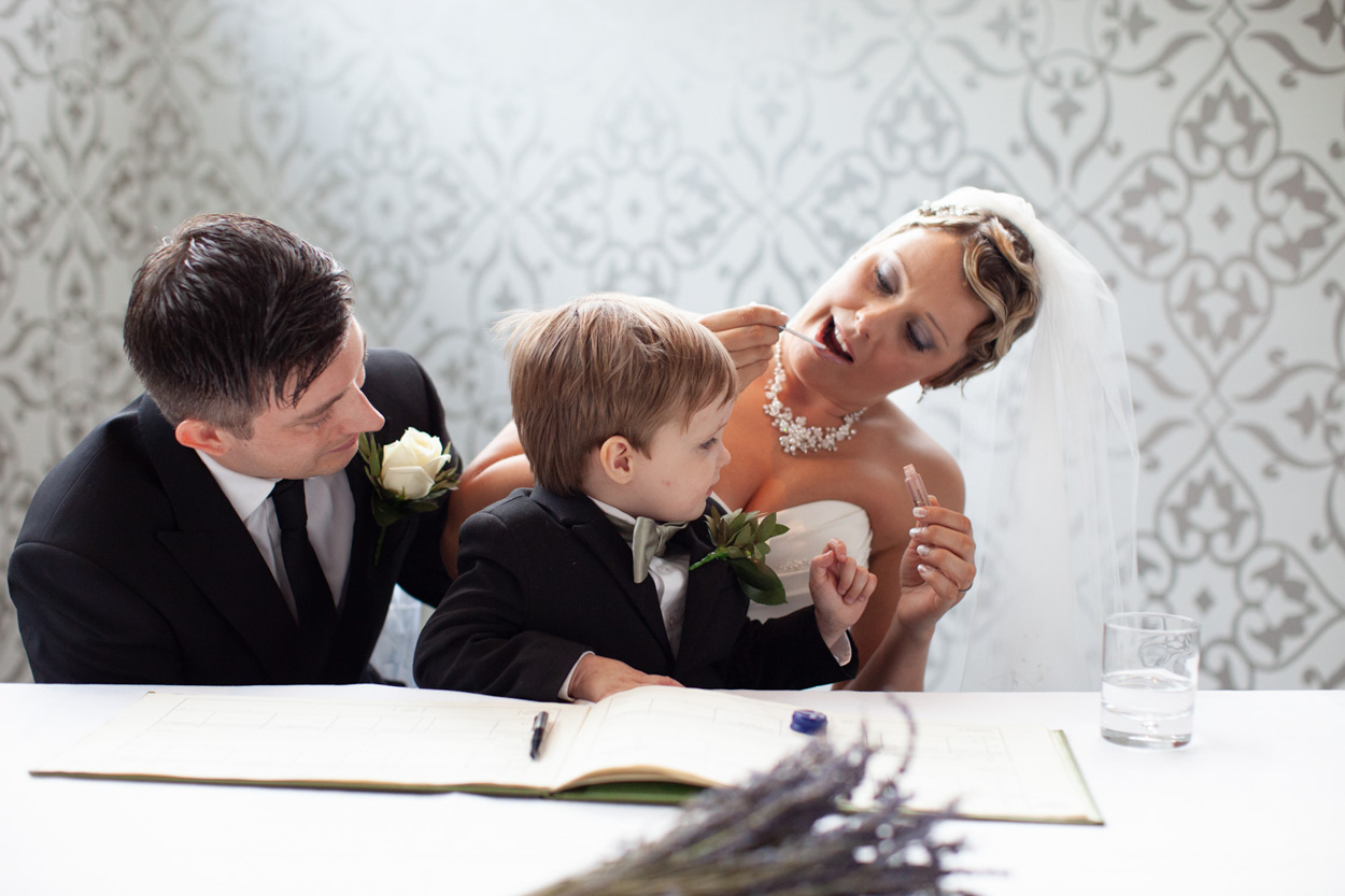 Couple share a look as they finish signing the wedding register.