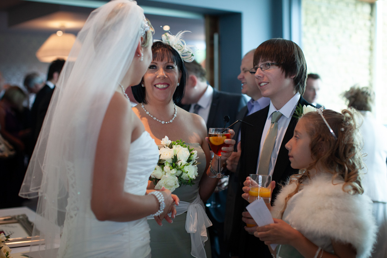 Tim greets his mum warmly, both smiling.
