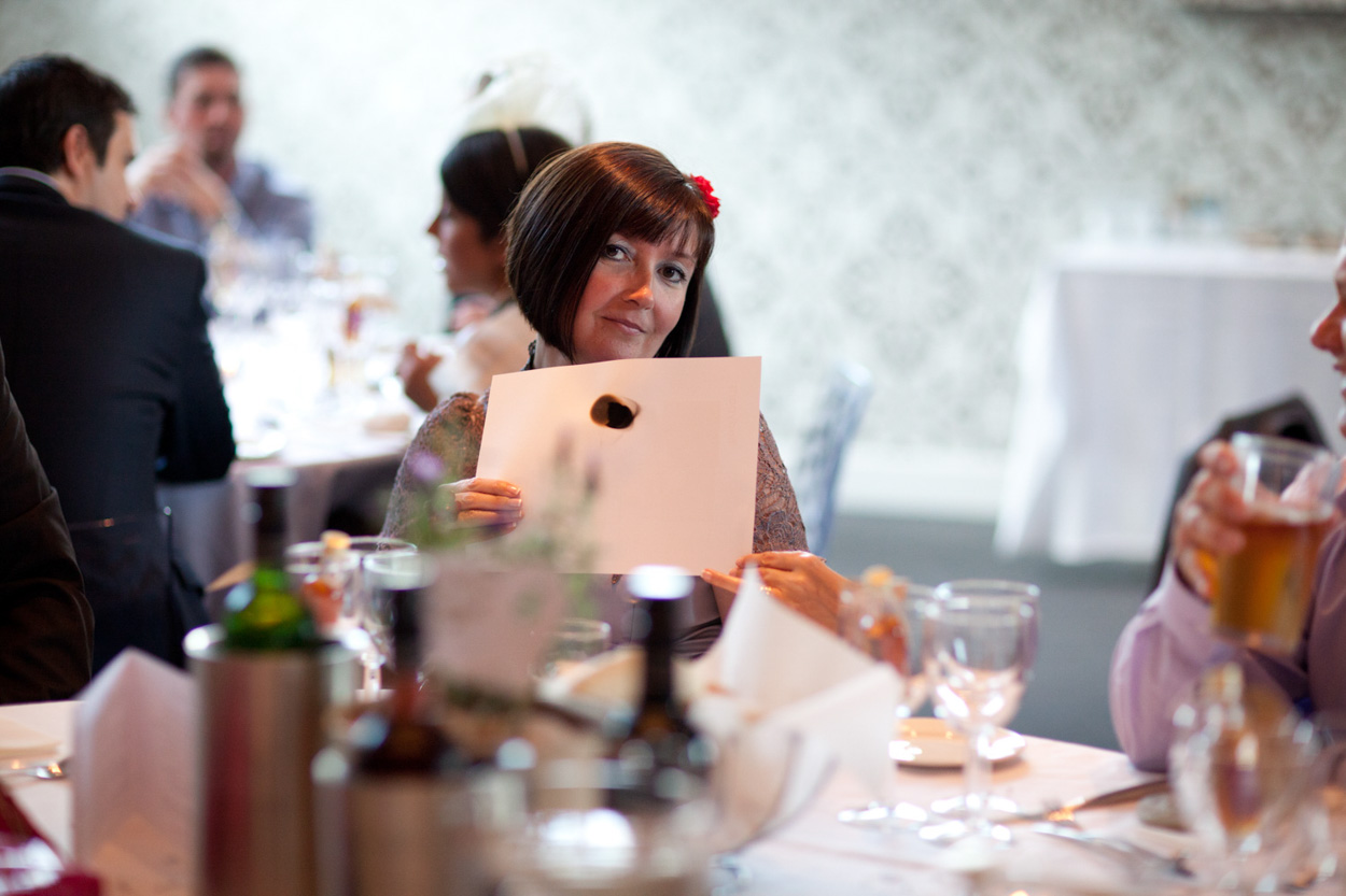 Best man chats with friends at the table, all relaxed and smiling during the reception.