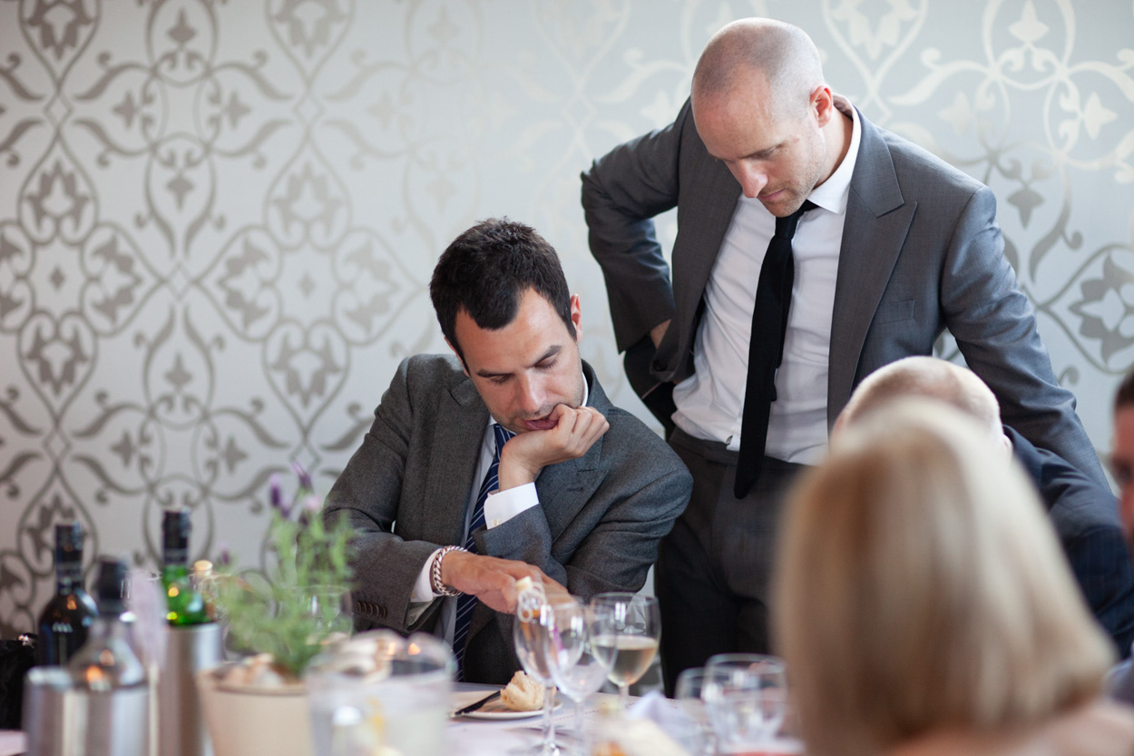Sam and Tim sit with their young son at the table, enjoying a quiet family moment.