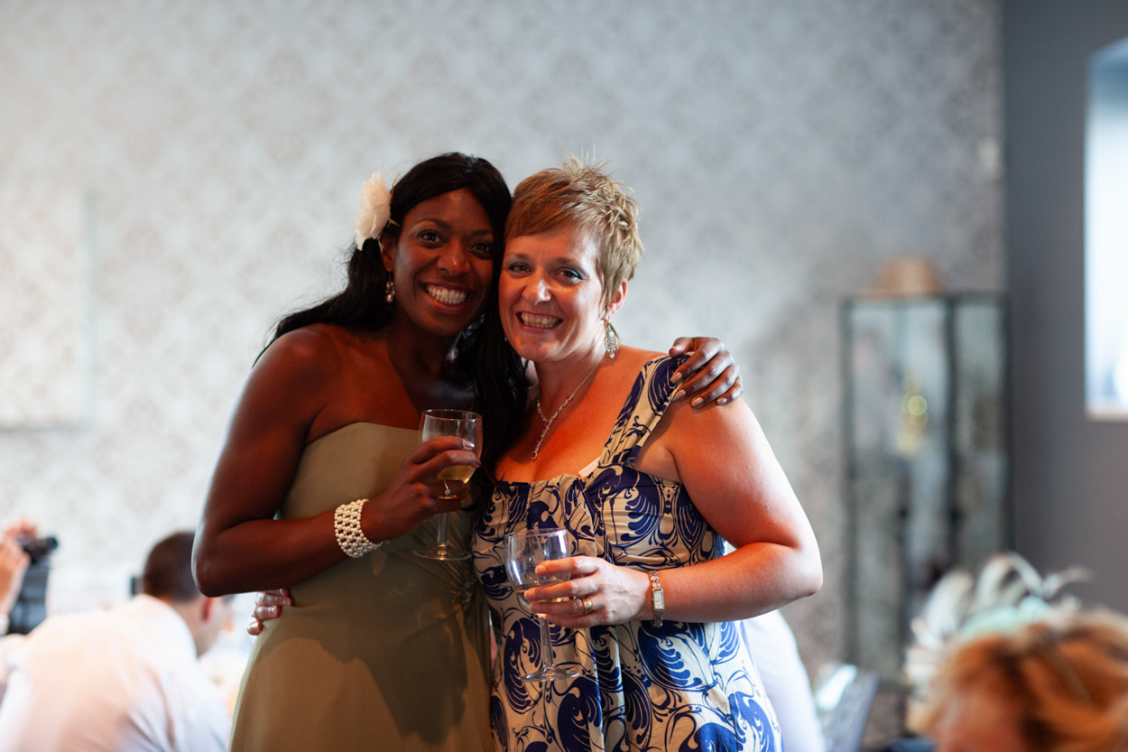 A guest lifts her wine glass and poses as she notices the camera.