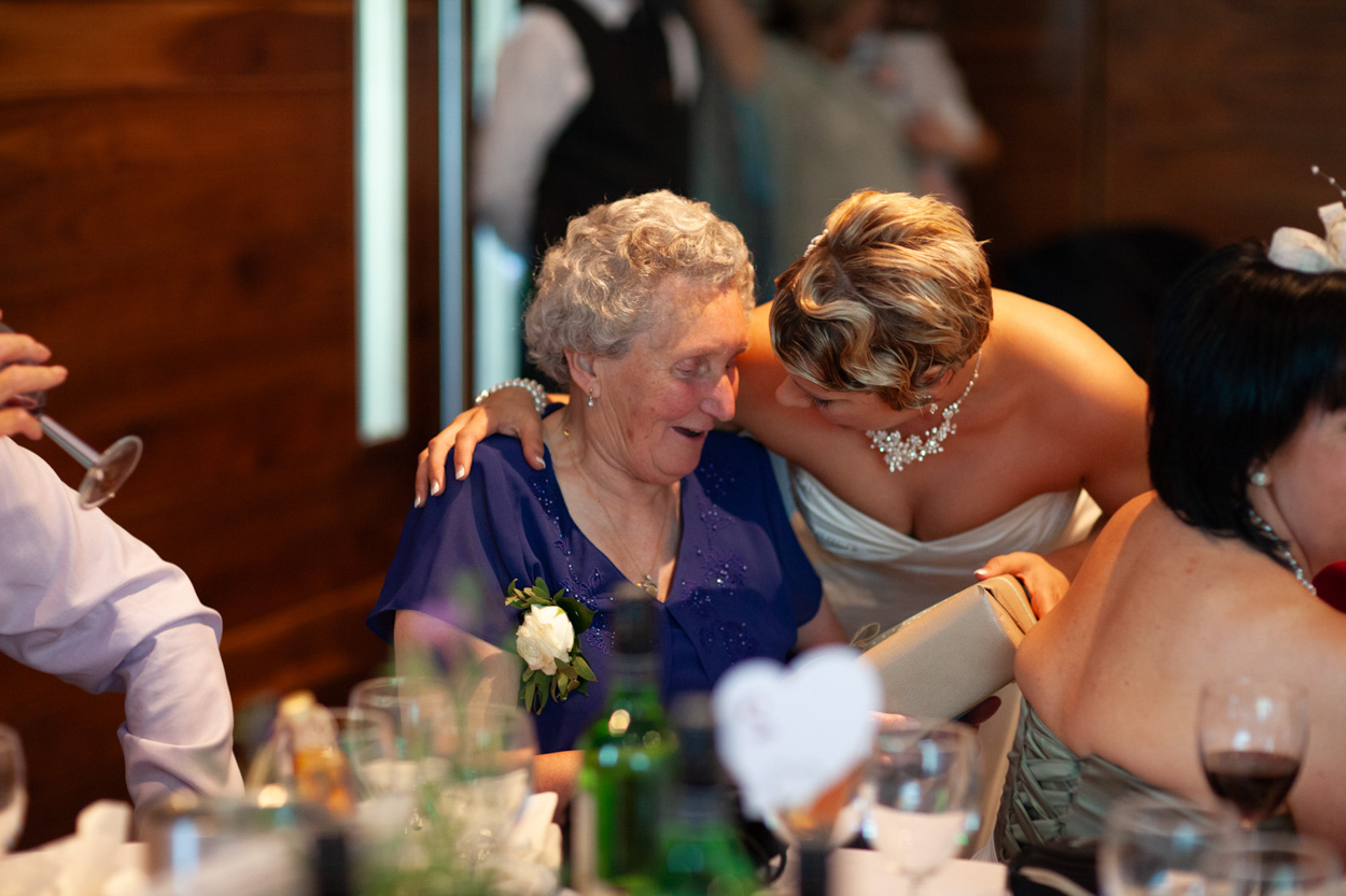 Sam sits beside her father, both smiling in a quiet, heartfelt moment.