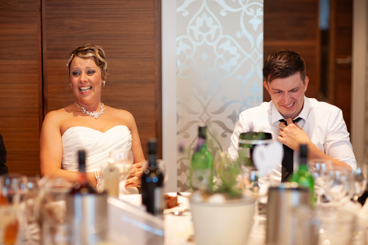 Sam leans into her father as he laughs and fist-pumps in amusement.