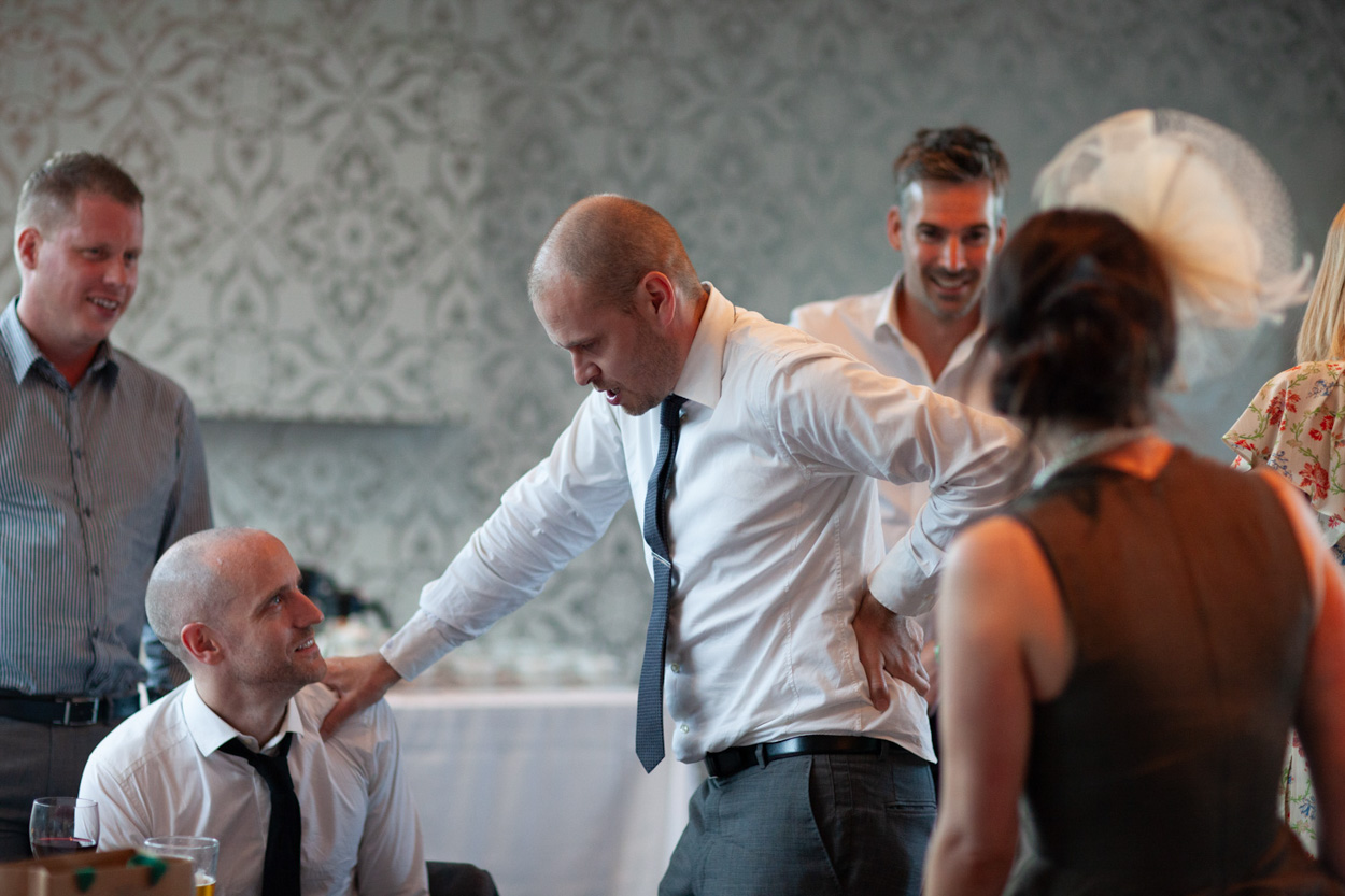 A bridesmaid joins Sam and her parents for a warm, smiling photo together.