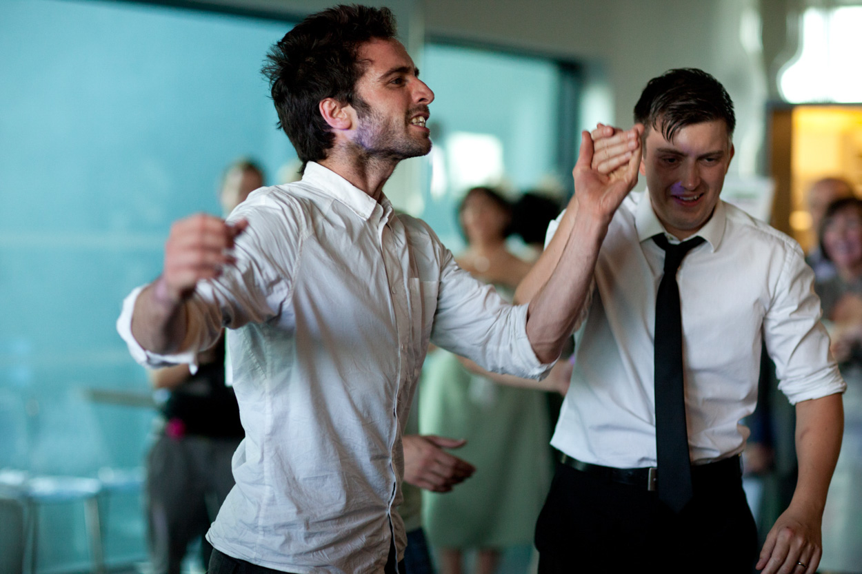 The crowd watches the breakdancers in awe, clapping and smiling.