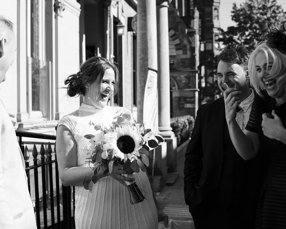 Bride laughing outside Lost & Found Leeds Club after a Leeds Civic Hall wedding.