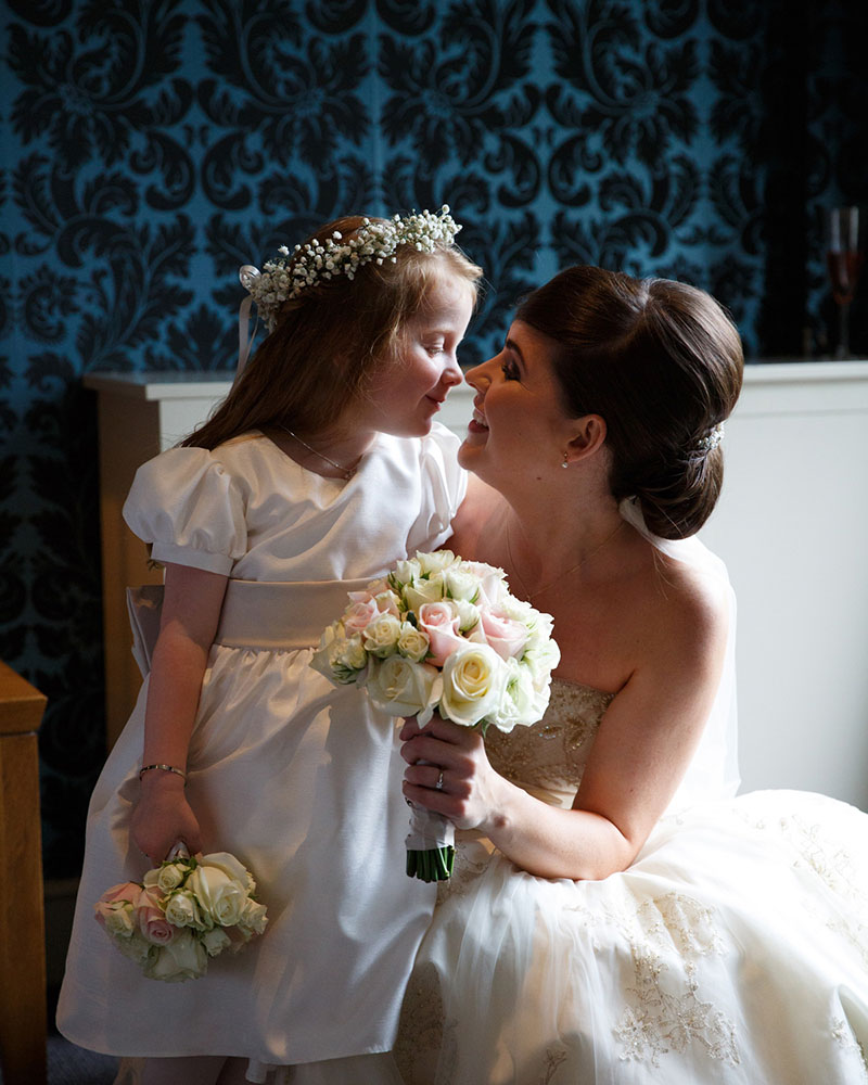 Bride and young daughter share a playful hug during the wedding breakfast in York.