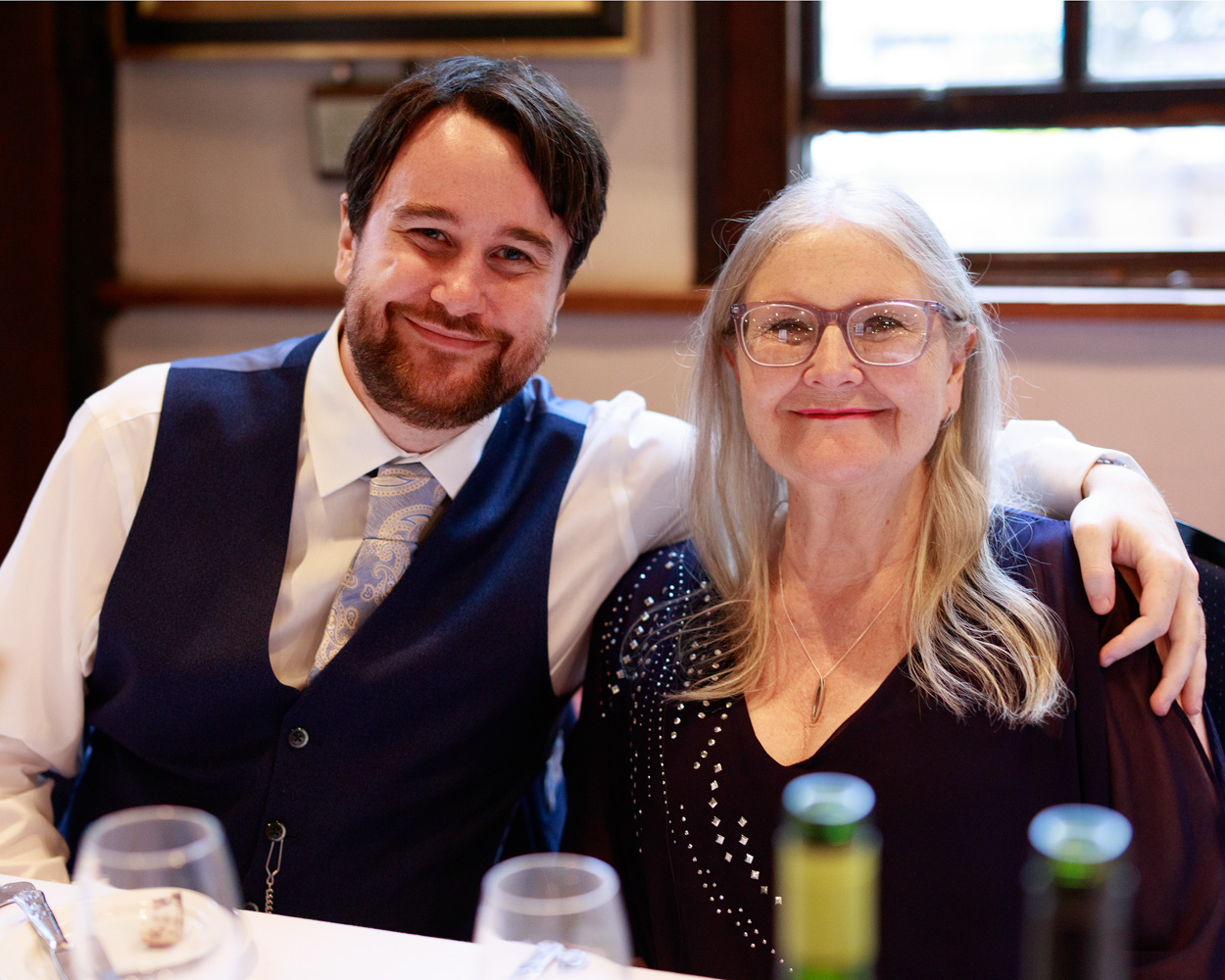 Groom Chris with his mother on the top table during the wedding breakfast at Merchant Adventurers Hall