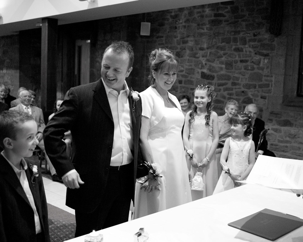 Wedding ceremony filled with smiling faces and shared joy, captured in black and white.