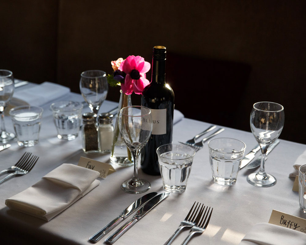 Rustic wedding breakfast table setting in a low light upstairs pub setting, captured naturally by a Leeds wedding photographer