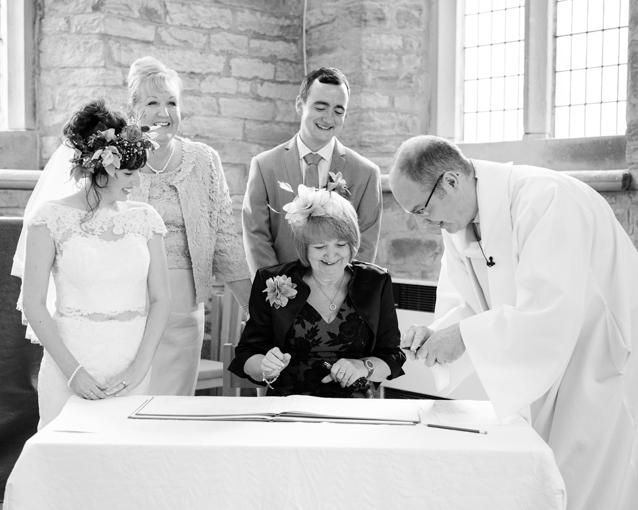 Black and white portrait-style shot of couple kneeling during blessing at St Paul’s Church.