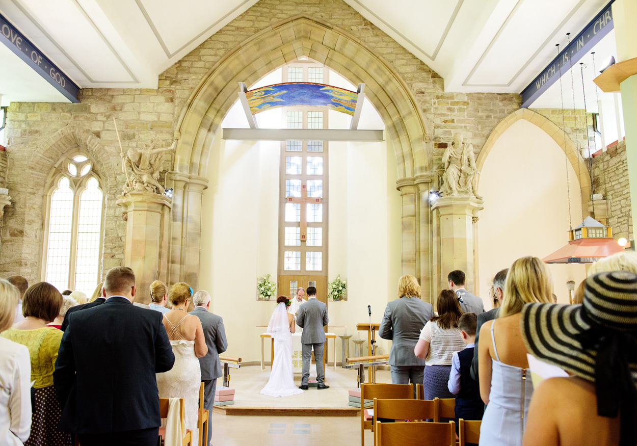 Couple framed through the stone gate at St Paul’s, sharing a colourful kiss.