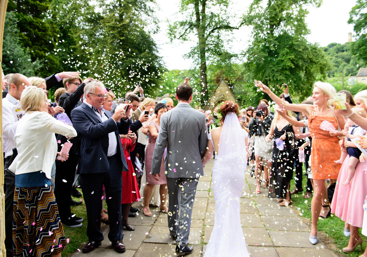 Bride and groom walk across the wooden bridge over the stream at Armitage Bridge.