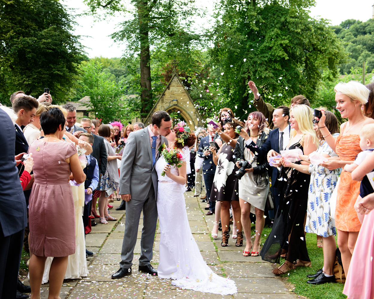In black and white, the couple smile from the bridge over the water.