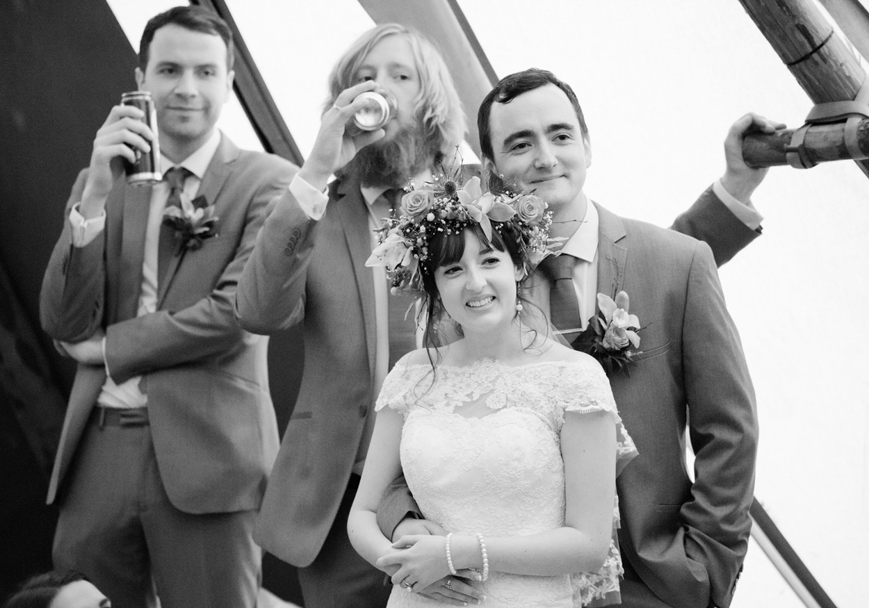 More wedding guests pose and laugh at the love photo frame outside.