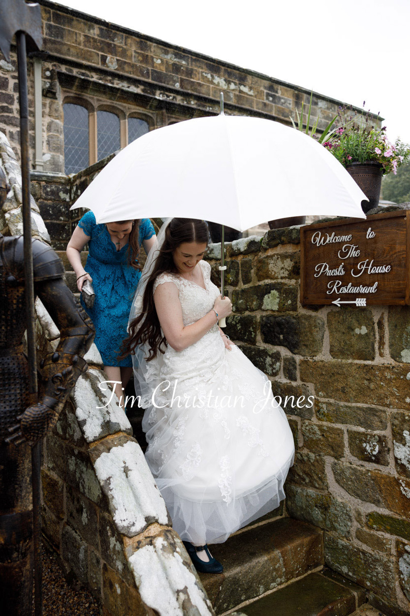 Summer rain, white umbrellas, the bride smiles