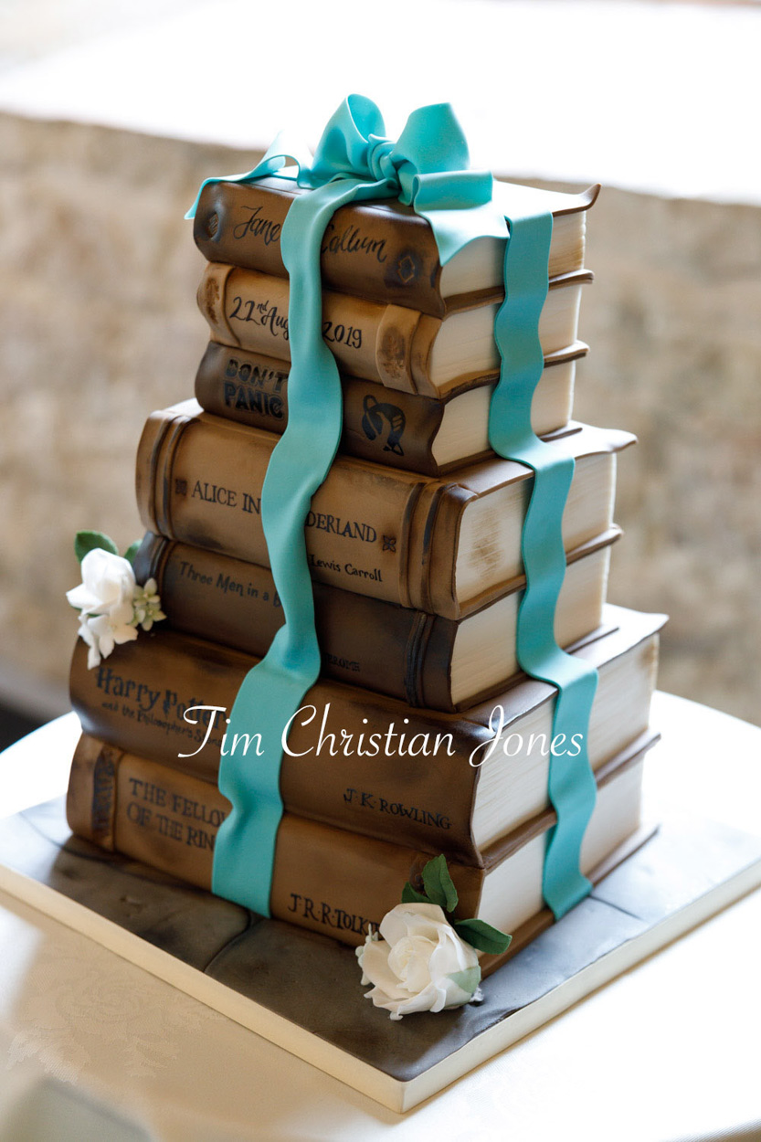 Wedding cake - a stack of books style with a blue icing ribbon - original details chosen by the couple for their Priests House, Barden Tower wedding.