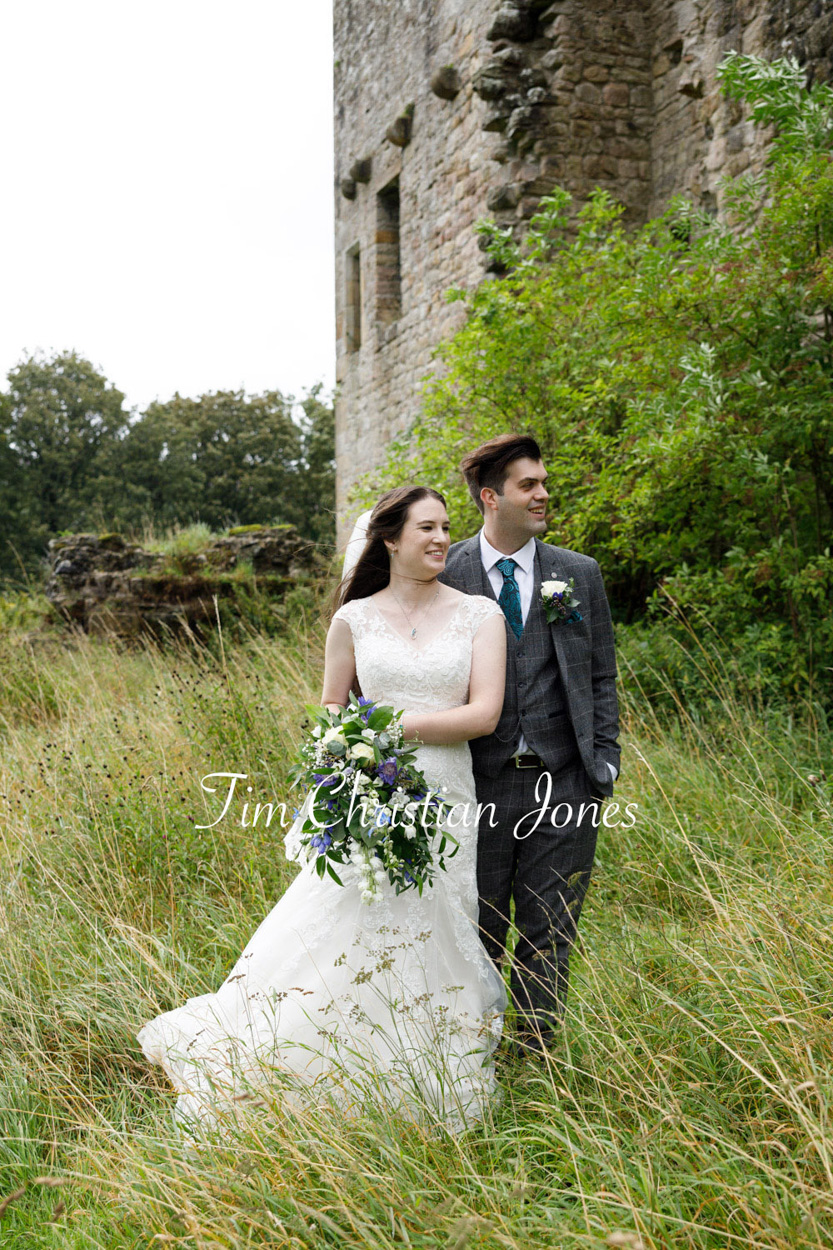 Couple portrait in the long grass alongside Barden Tower