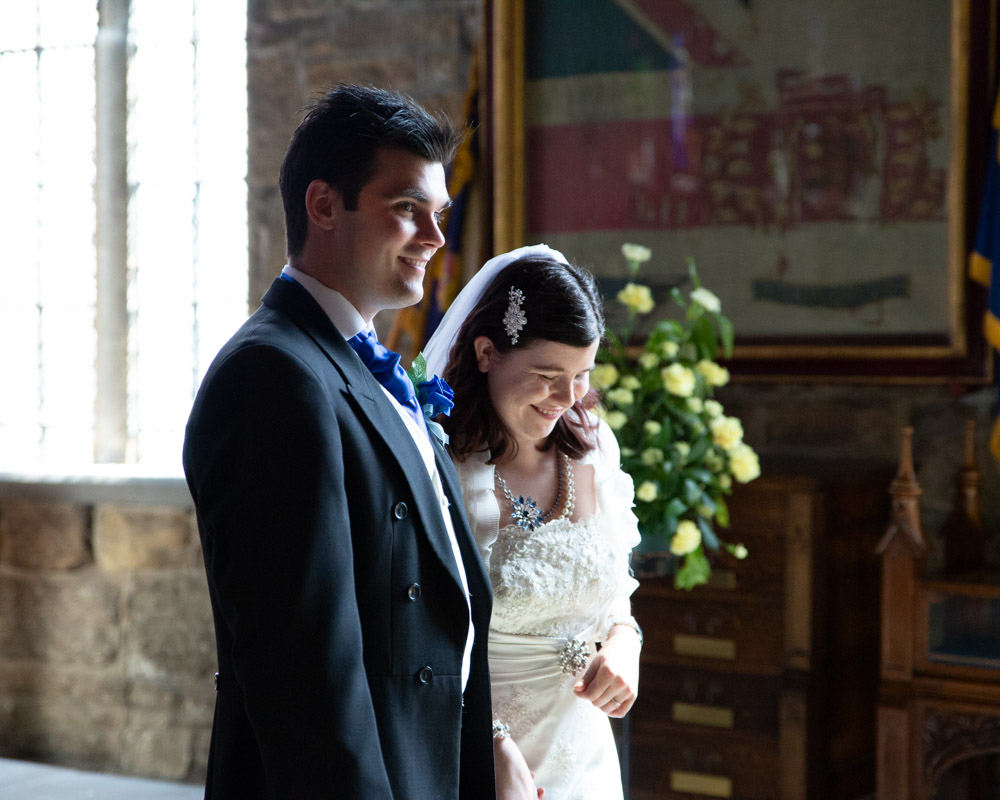 Bride laughing and groom smiling together in a quiet vestry moment before signing the register.