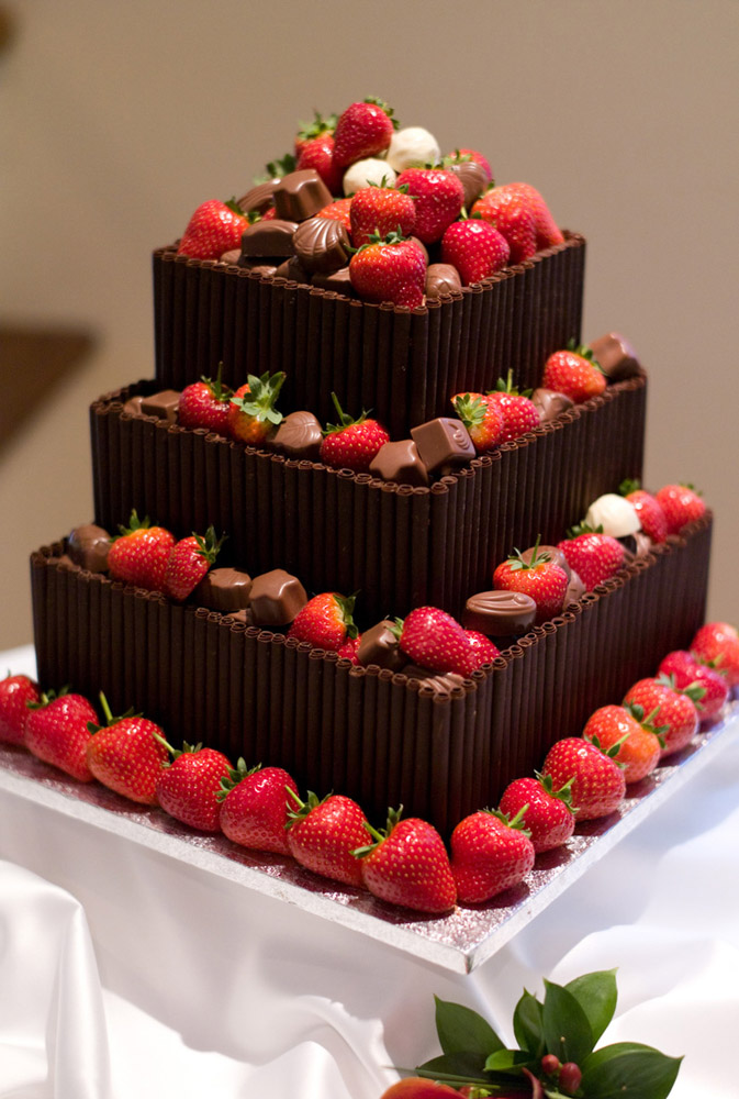 Wedding cake decorated with strawberries and chocolates at an evening reception—beautiful natural wedding detail captured in true colour by Leeds wedding photographer Tim Christian Jones