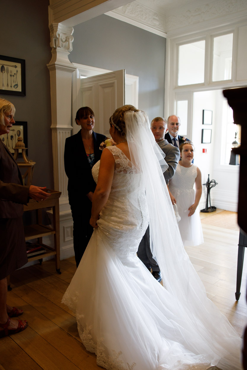 Bride with flowing veil talking to the registrars at The Woodlands Hotel in Leeds Yorkshire