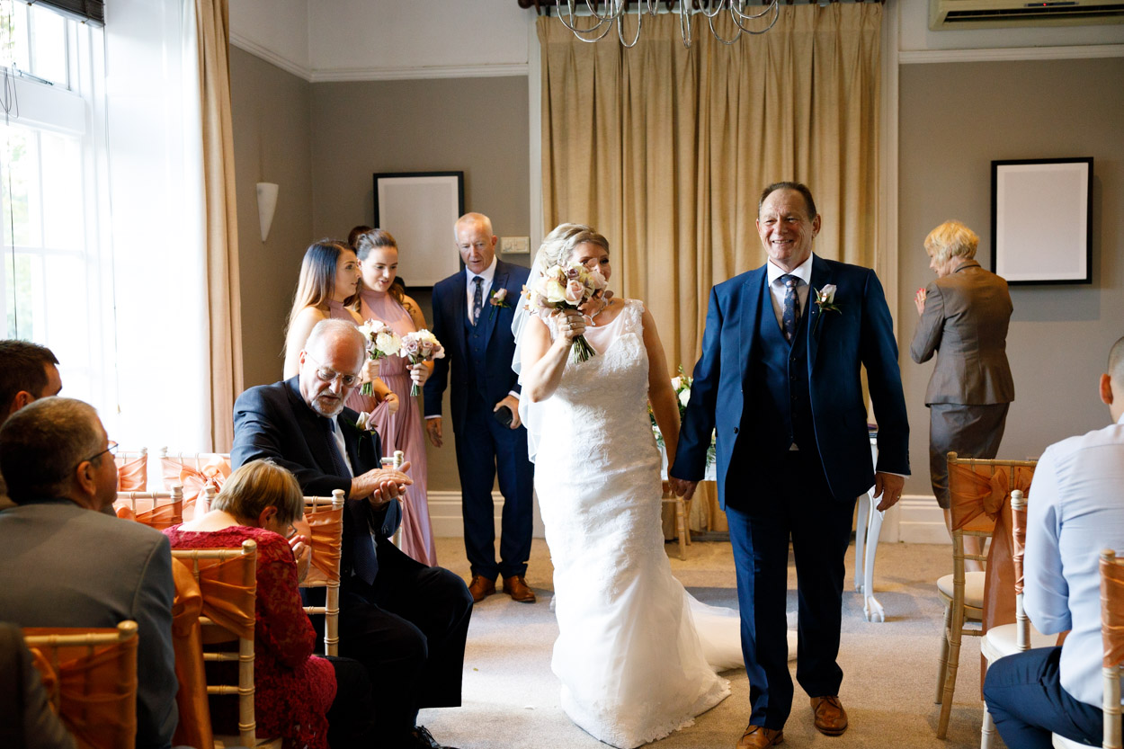 The couple exit the ceremony room at the Woodlands Hotel in Leeds